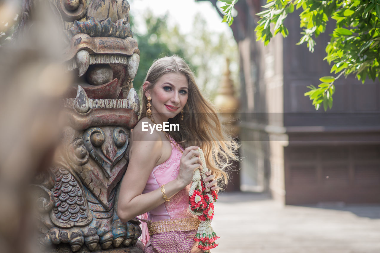 Young woman with sculpture in temple