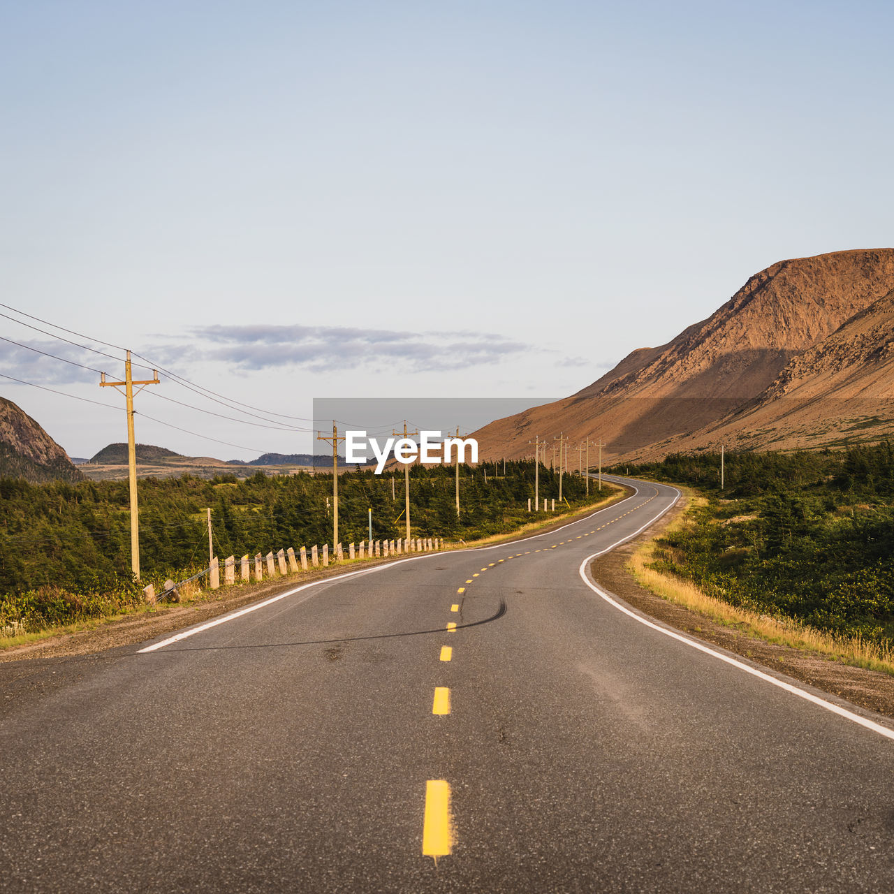 EMPTY ROAD ALONG COUNTRYSIDE MOUNTAINS