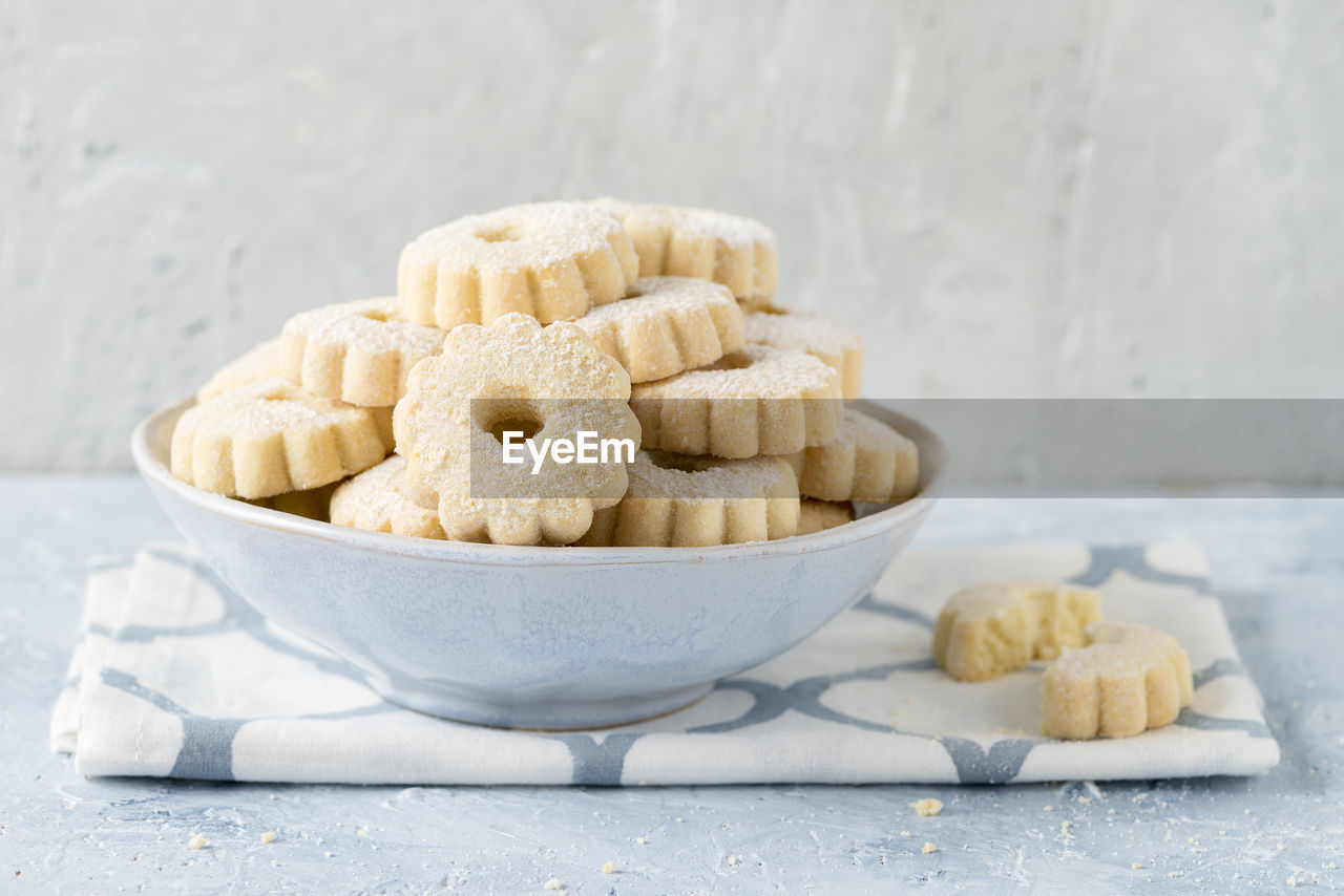 Front view of homemade baked cookies in a cup with powdered sugar