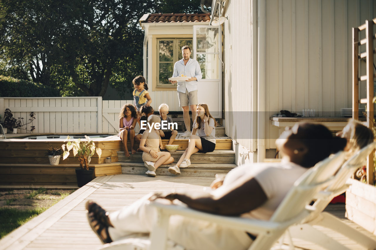 Family spending leisure time at patio during sunny day