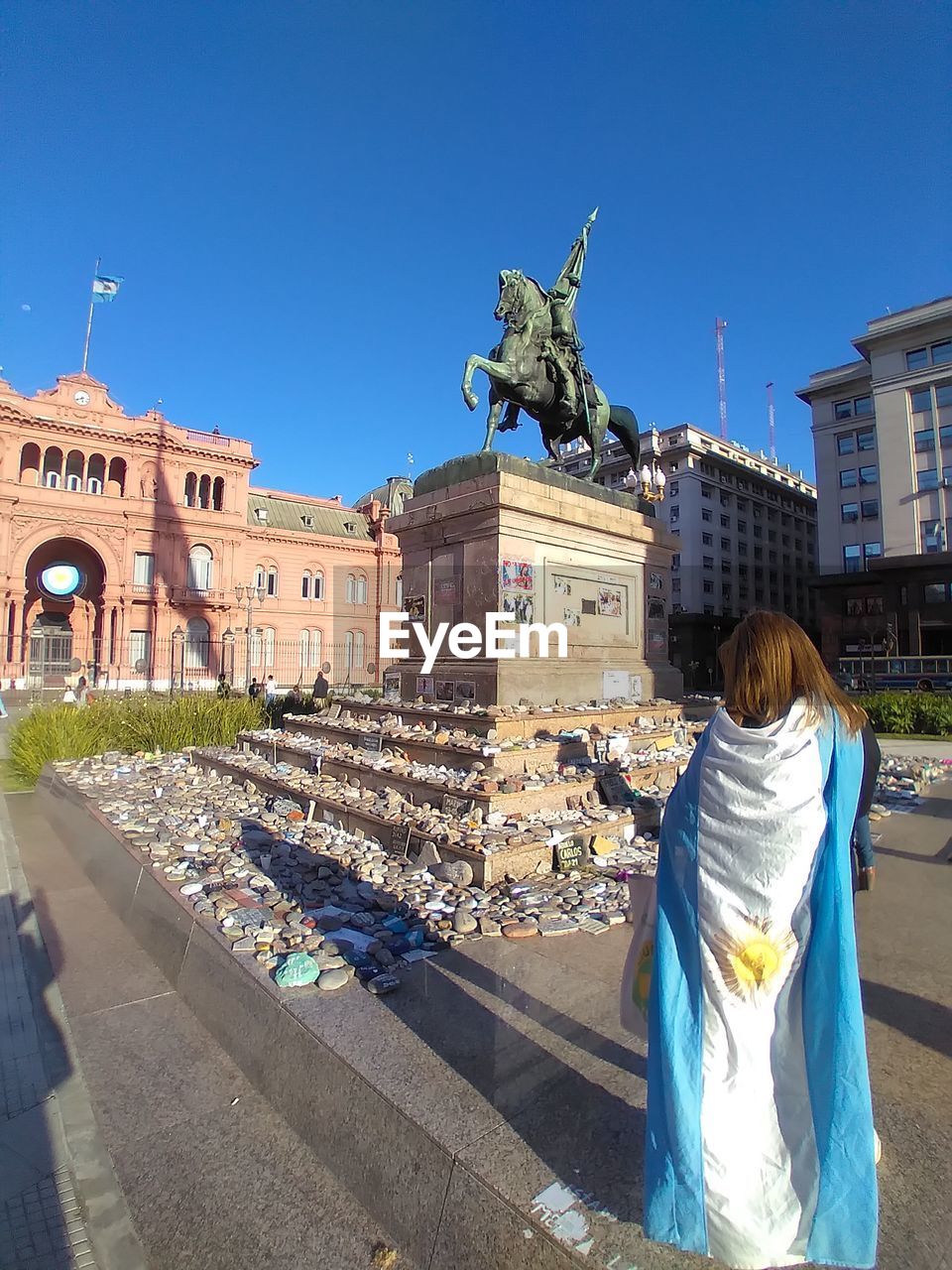 REAR VIEW OF STATUE IN CITY AGAINST SKY
