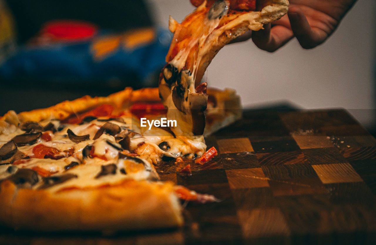 Selective focus of italian pizza, spices in grinders, bottle and glass of wine on wooden tabletop