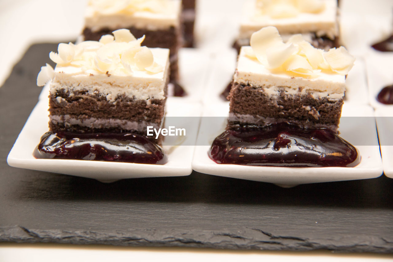 Desserts in plates on slate on table