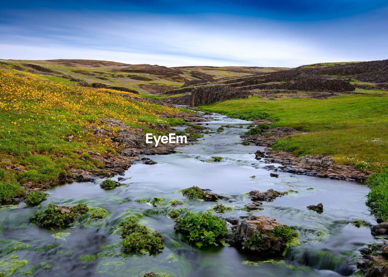 Scenic view of river amidst mountains against sky