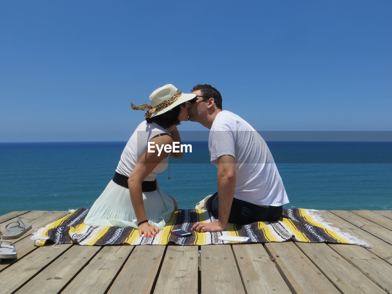 People on sea shore against clear sky