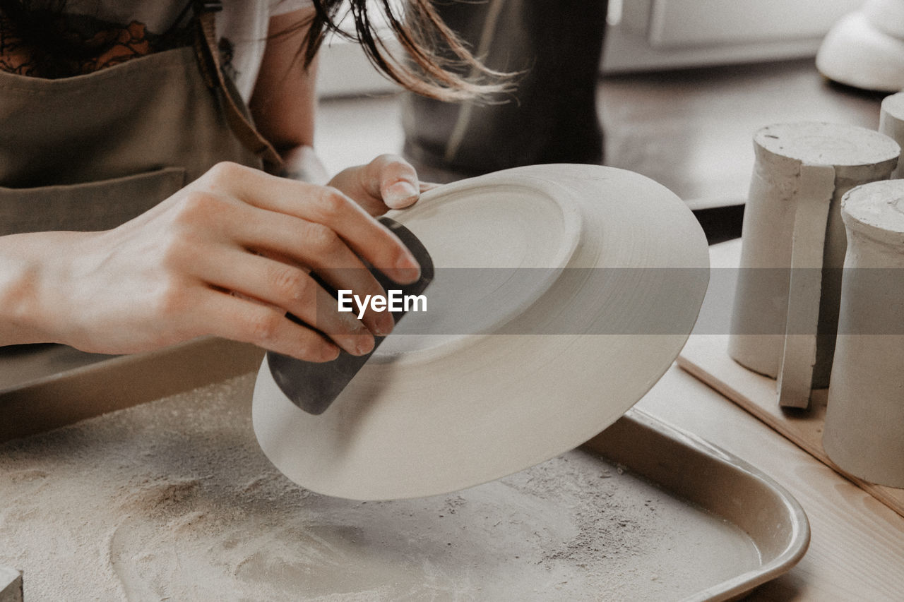 Midsection of woman at pottery workshop