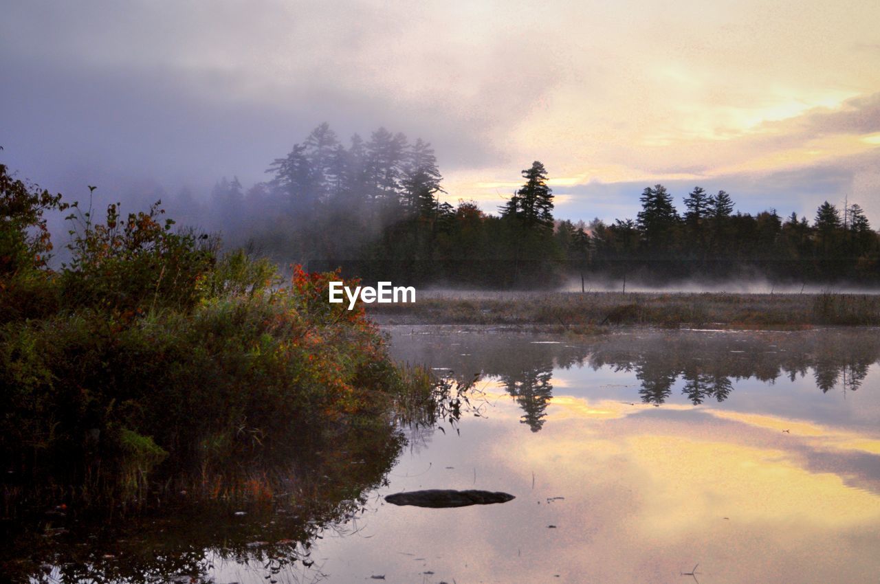 Scenic view of lake against sky at sunset