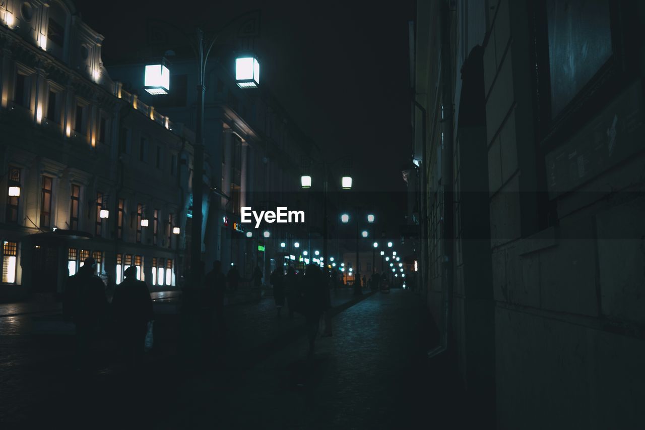 Street and footpath amidst buildings at night