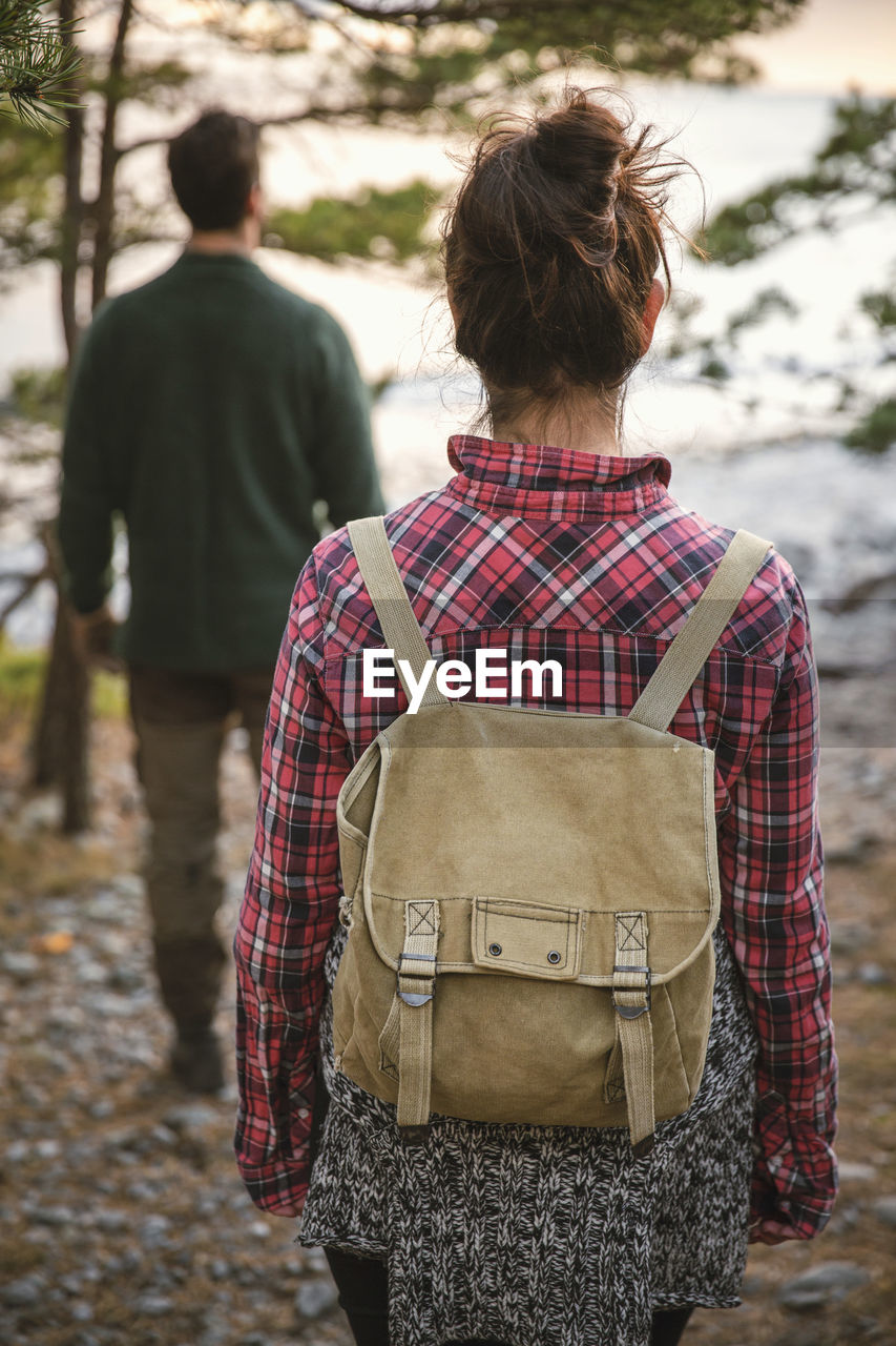 Rear view of couple hiking in forest