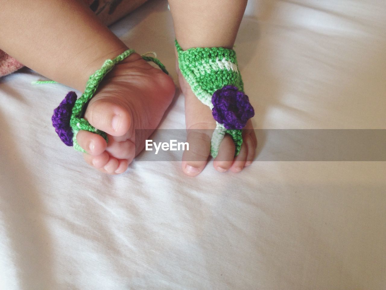 Close-up of baby feet with socks on bed