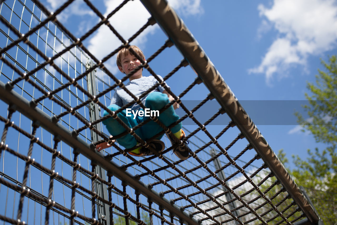 Low angle view of boy against sky