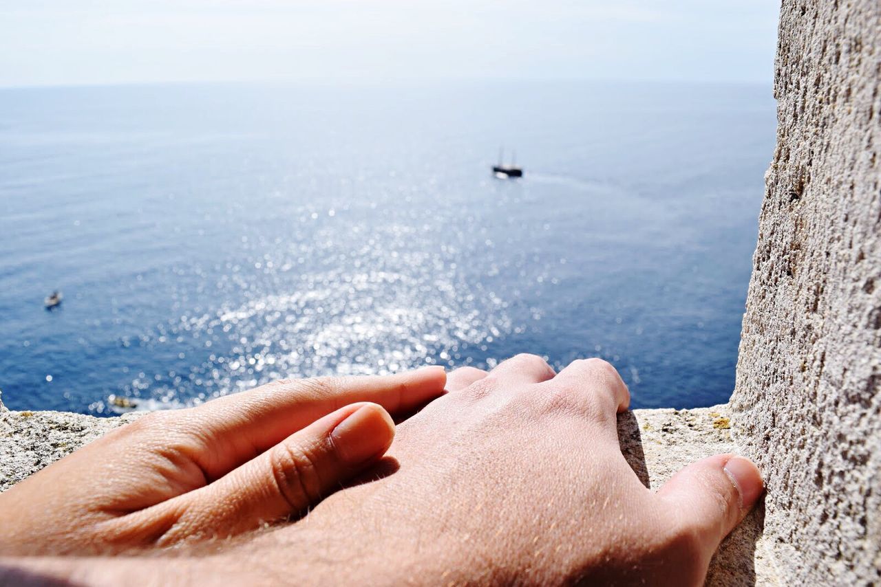Cropped image of hand holding sea