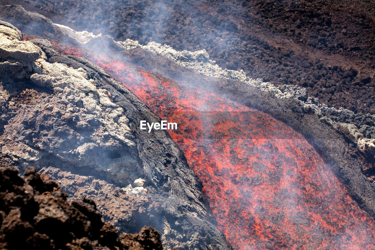 Etna- lava fall detail on volcano  in sicily with smoke and acid vapor
