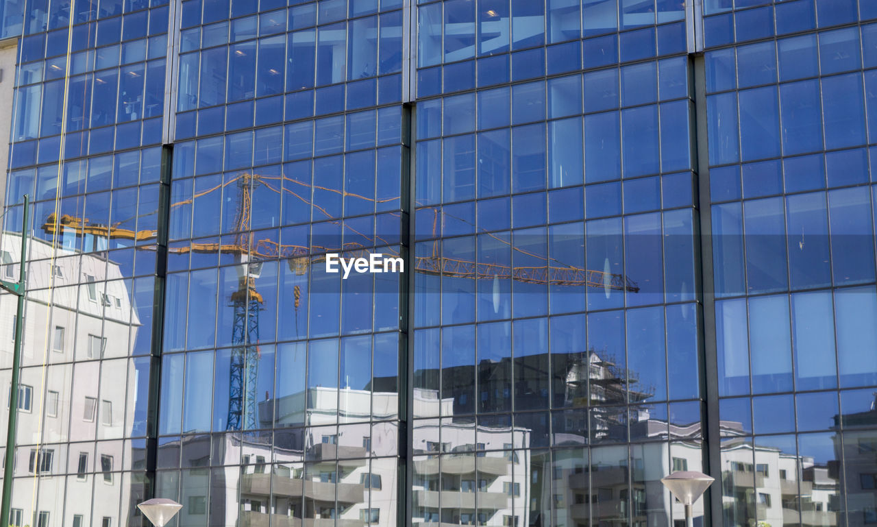 FULL FRAME SHOT OF MODERN GLASS BUILDING WITH REFLECTION