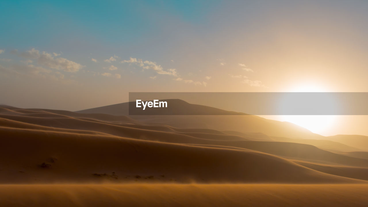 Scenic view of desert against sky during sunset