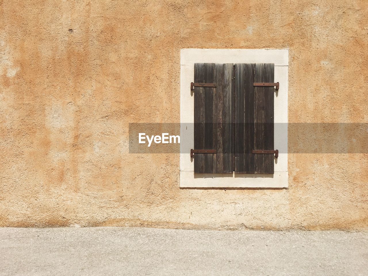 View of closed wooden window in building during sunny day