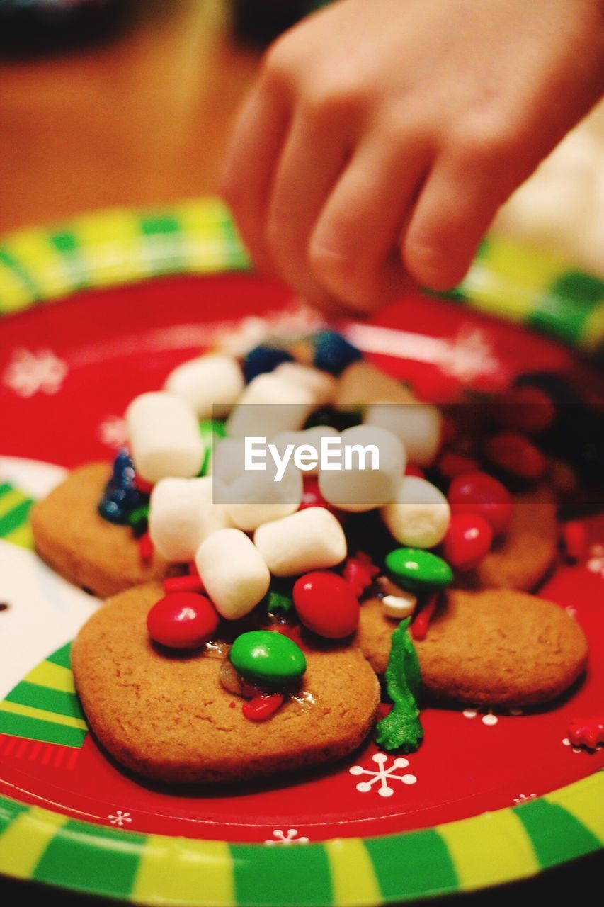 Cropped hand decorating cookies during christmas