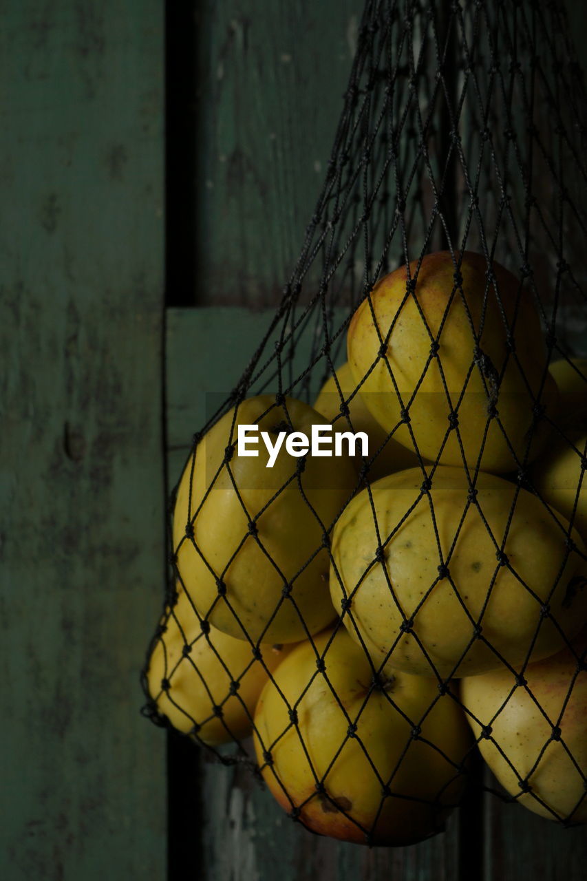 Close-up of yellow bell hanging on wall