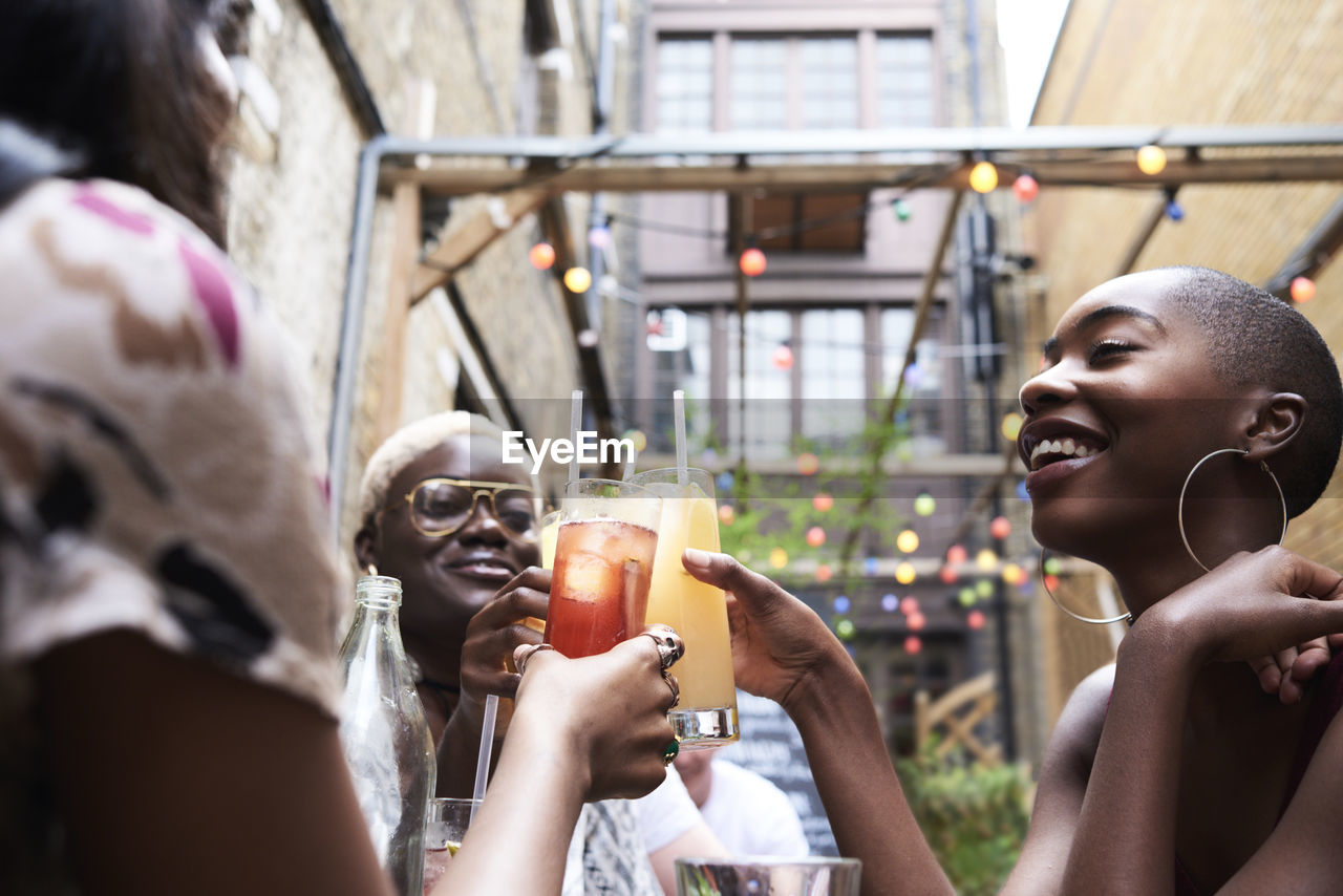 Three friends toasting with cocktails