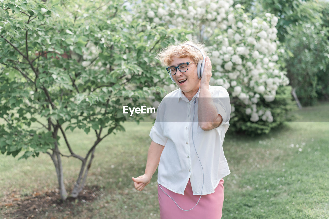 Full length of woman standing by tree