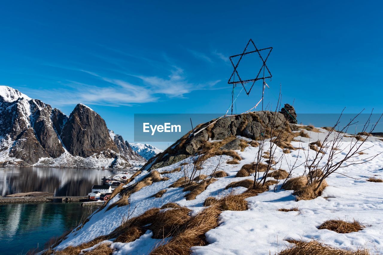 Symbol on snowcapped mountain against clear blue sky