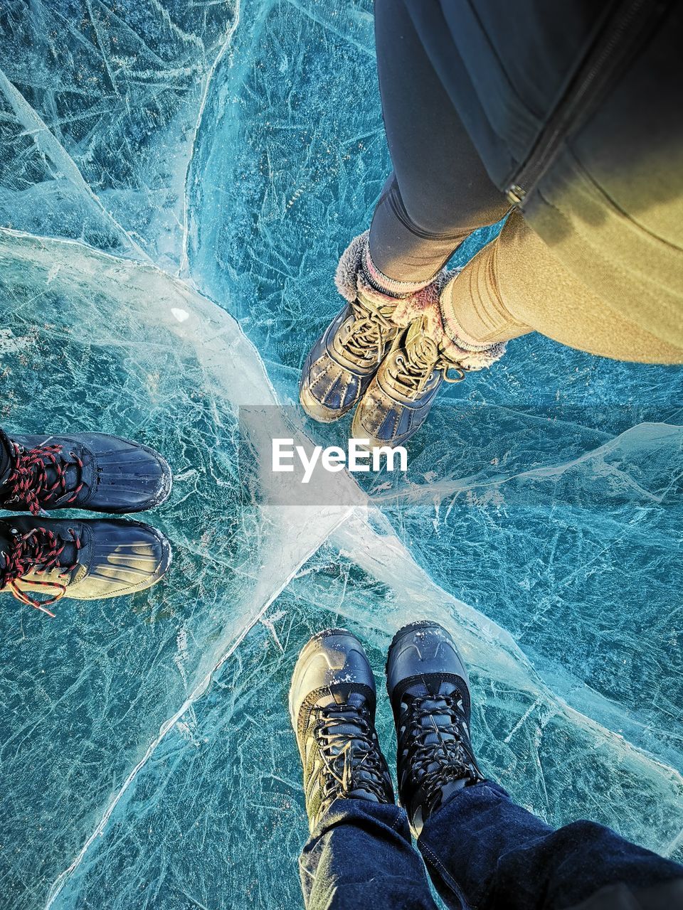 Low section of people standing on frozen lake