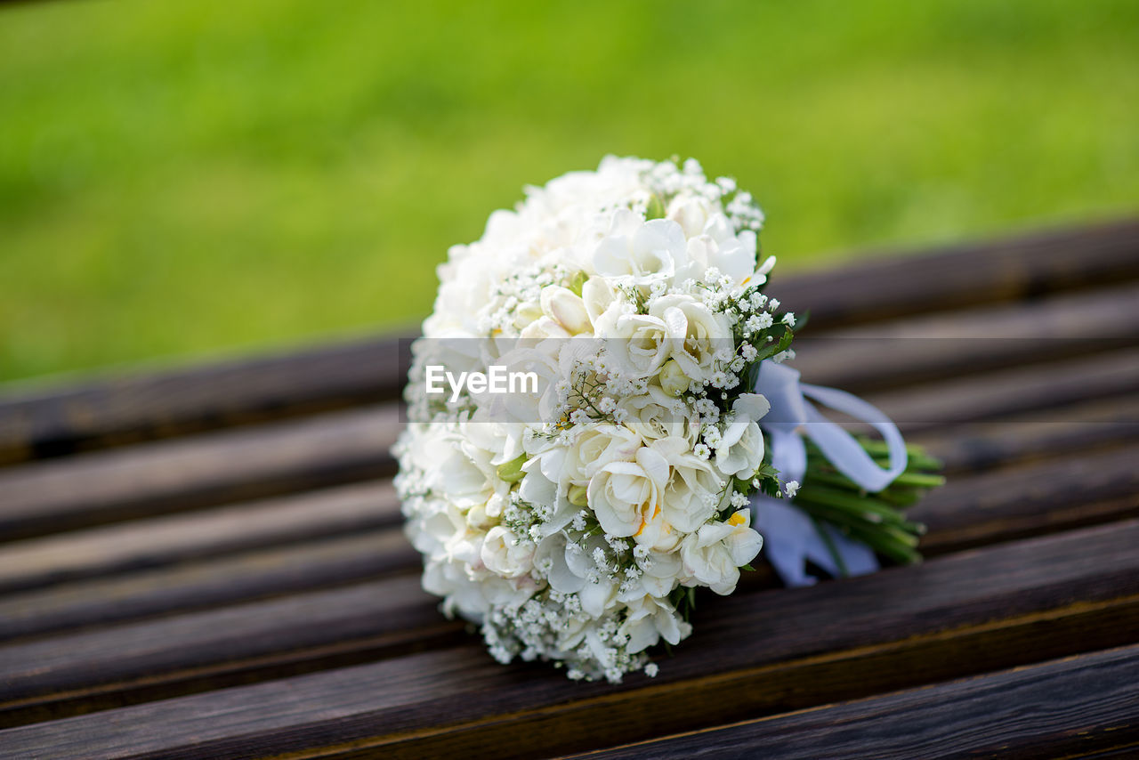CLOSE-UP OF WHITE ROSE BOUQUET ON TABLE