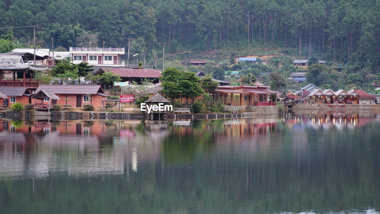 Houses by lake and buildings in village