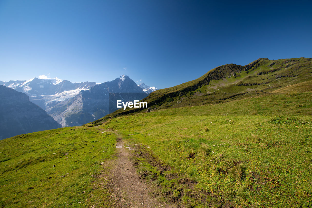 Scenic view of mountains against clear blue sky