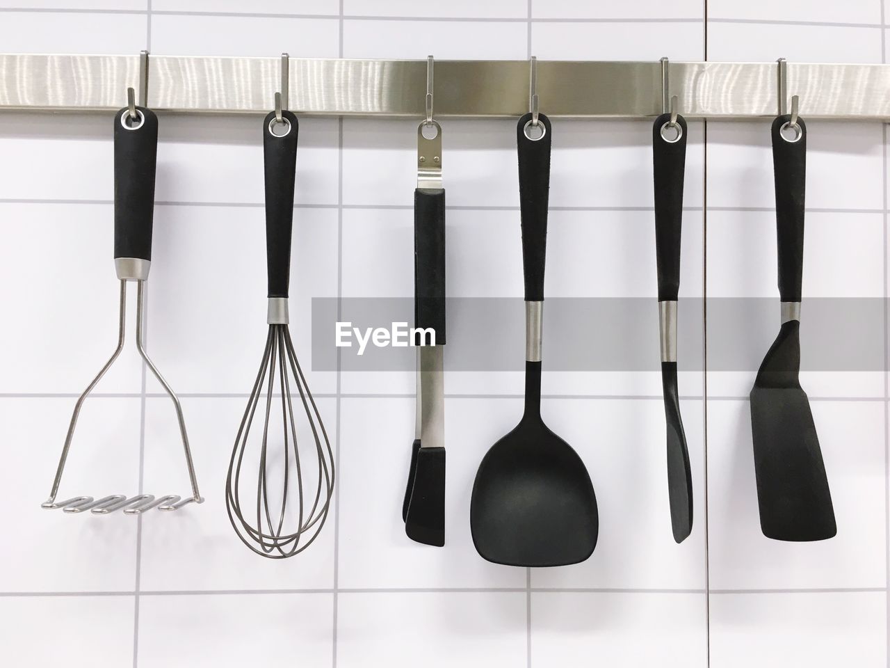 Close-up of kitchen utensils hanging on rack 
