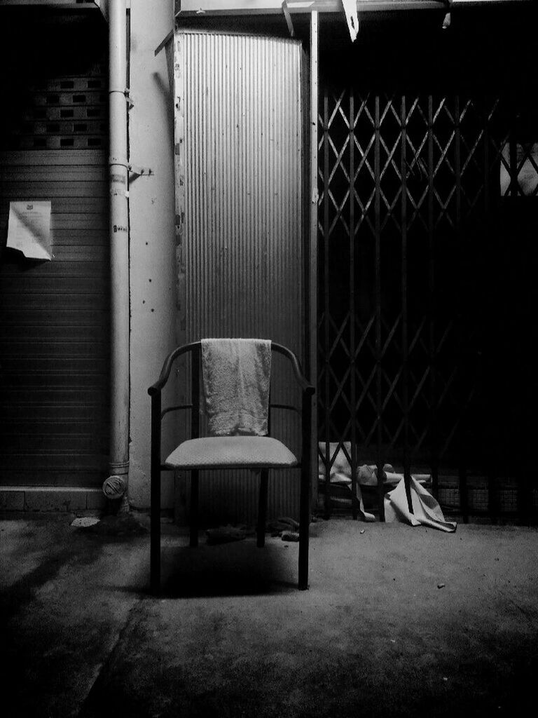 Empty chairs on street at night