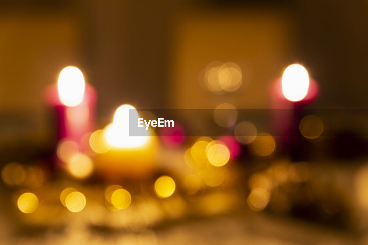 Christmas decoration on a dining table. burning candles, balls, stars and tinsel. blurred effect.