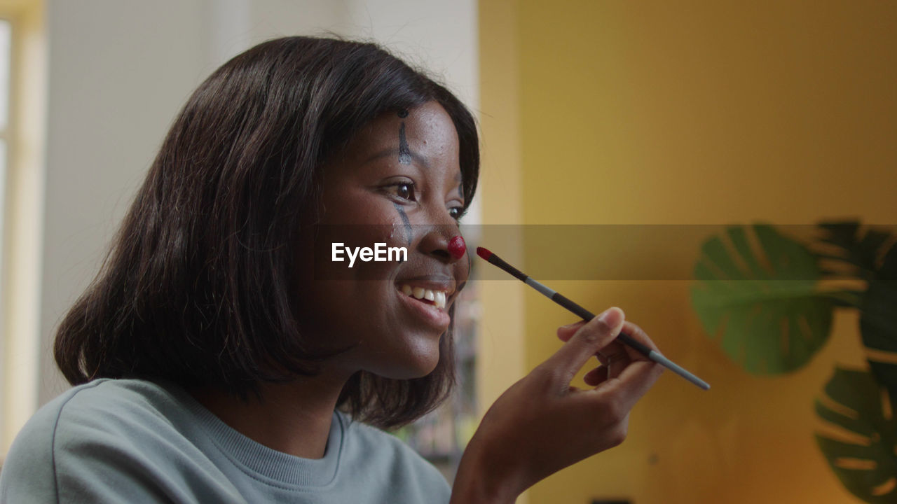 Close-up of young woman applying make-up brushes