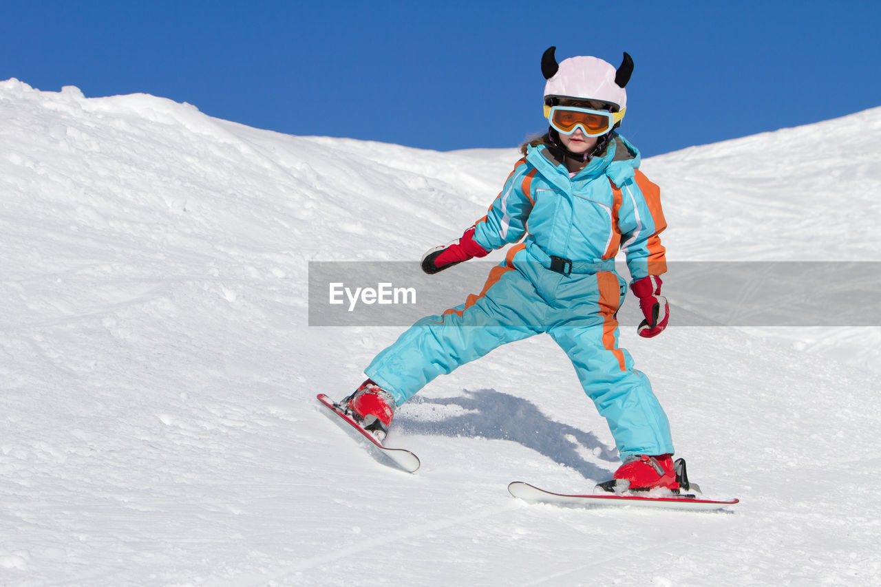 Teenage girl skiing skiing on snowy mountain
