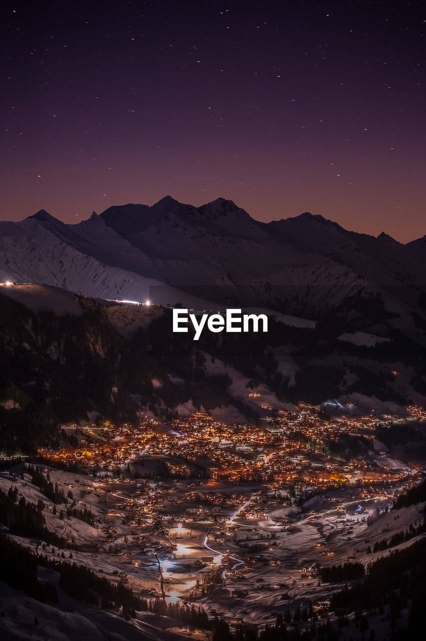 Aerial view of snowcapped mountains against sky at night