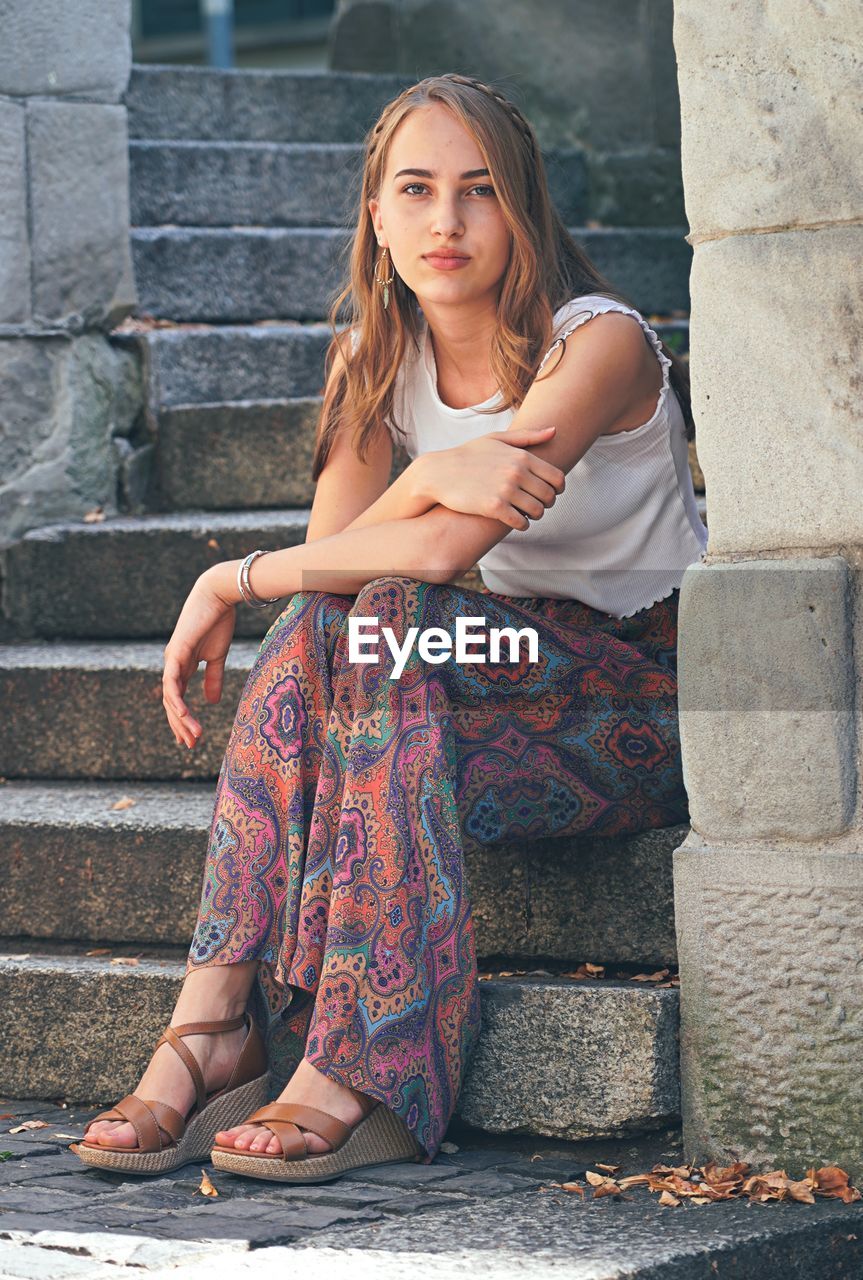 Portrait young woman sitting on staircase