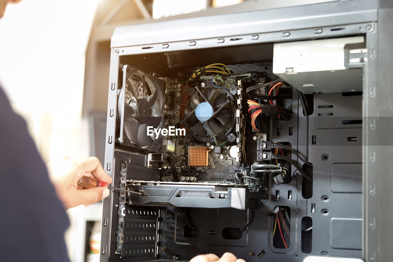 Midsection of man repairing electrical equipment