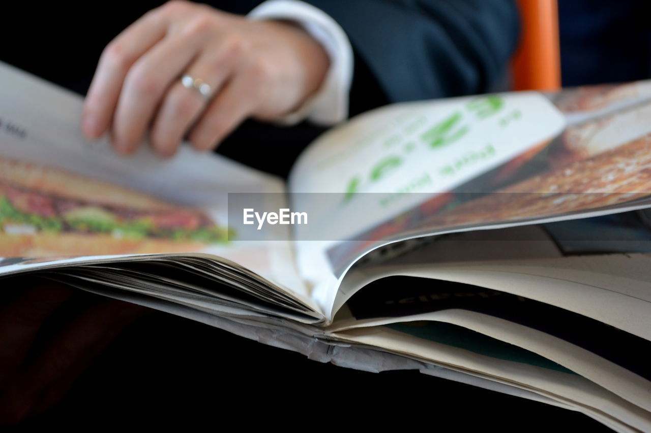 Cropped hand holding book in train