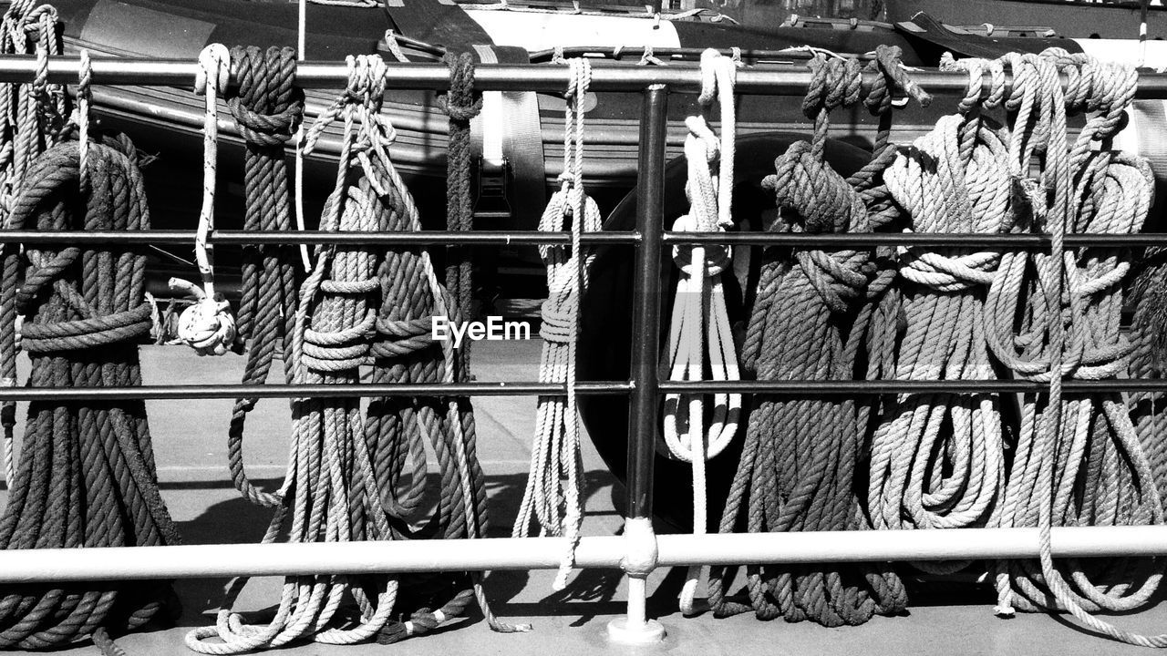 Ropes tied on metallic railing during sunny day