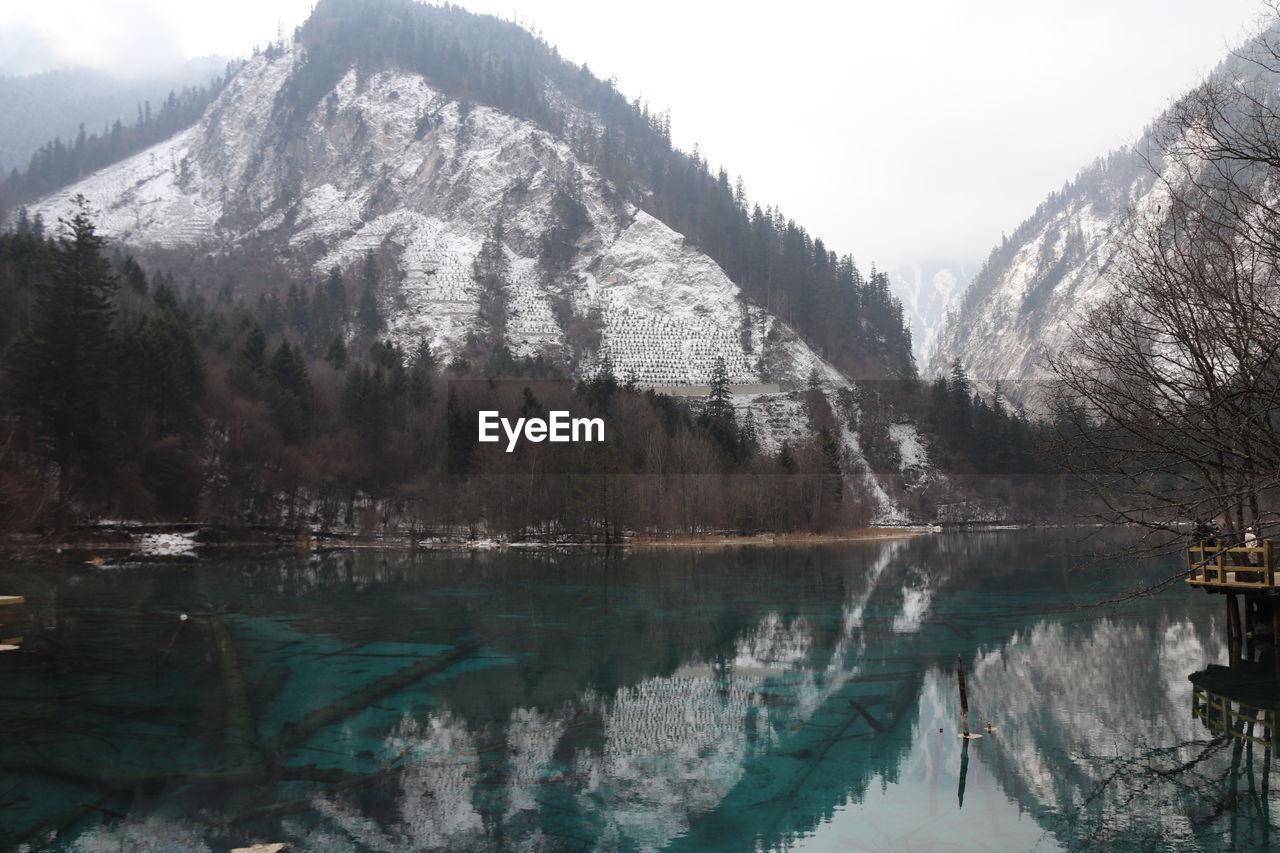 Beatiful landscape of a lake between mountains with reflexion of trees in the water in jiuzhaigou 