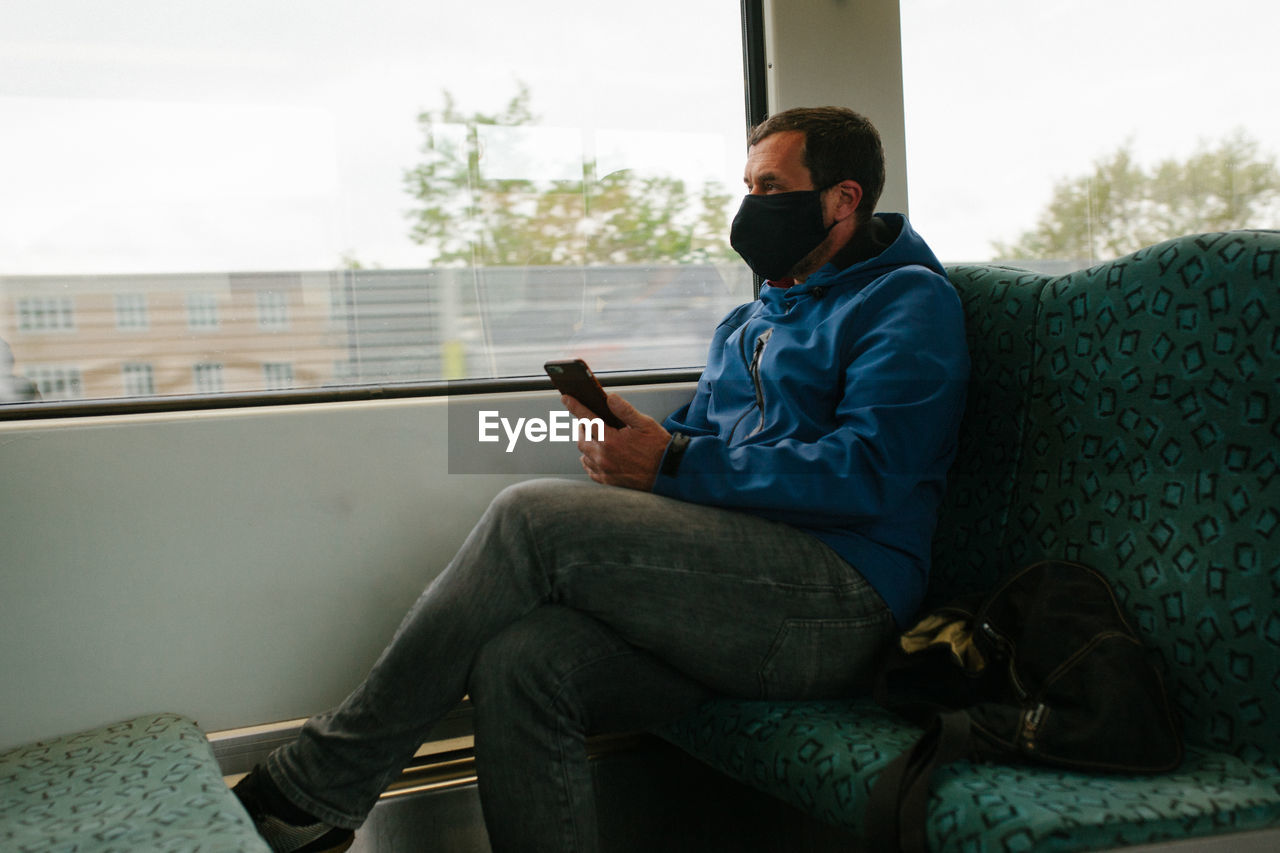 Man wearing mask while traveling in train
