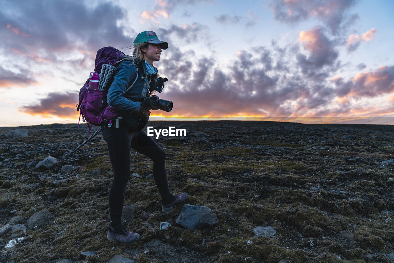 Backpacking photographer takes photos at sunset in remote highlands