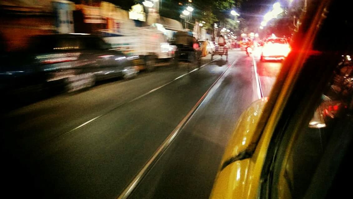 CARS MOVING ON STREET AT NIGHT