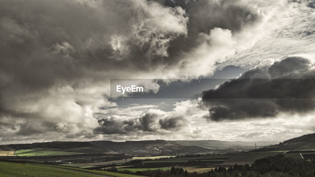 Scenic view of field against cloudy sky