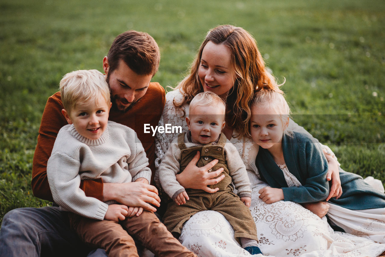 Good looking smiling family sitting in a park