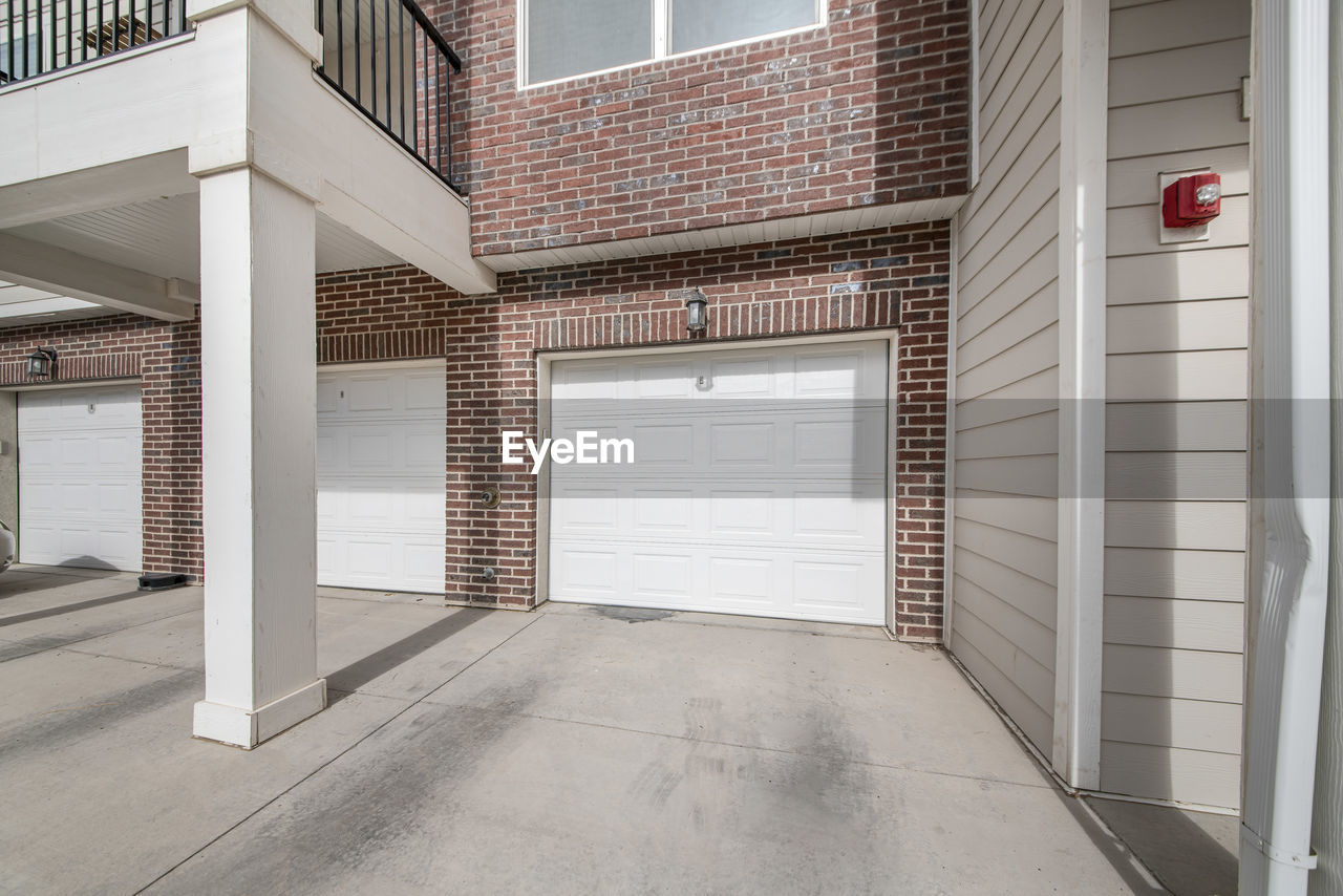 EMPTY ROAD AMIDST BUILDINGS AGAINST SKY