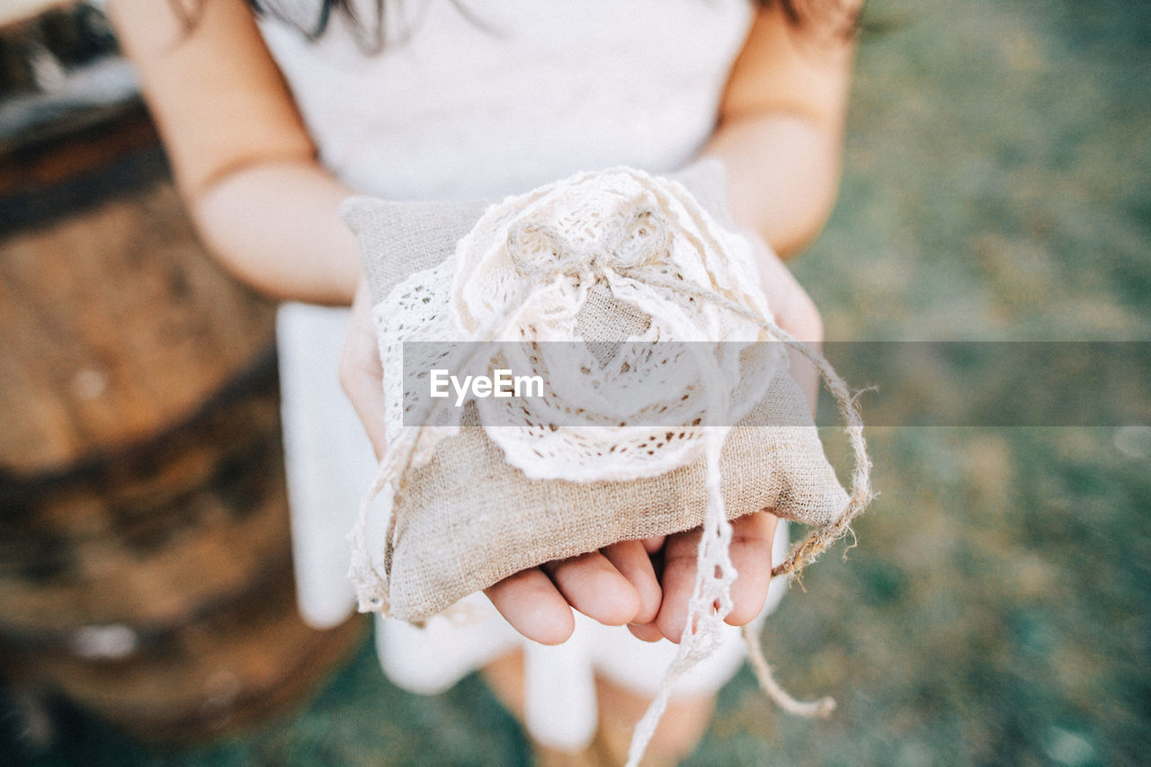 Close-up of woman holding burlap ring bag