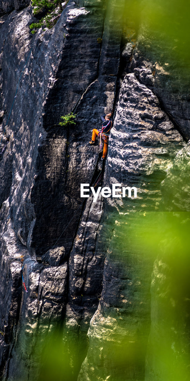 Distant view of man rock climbing 