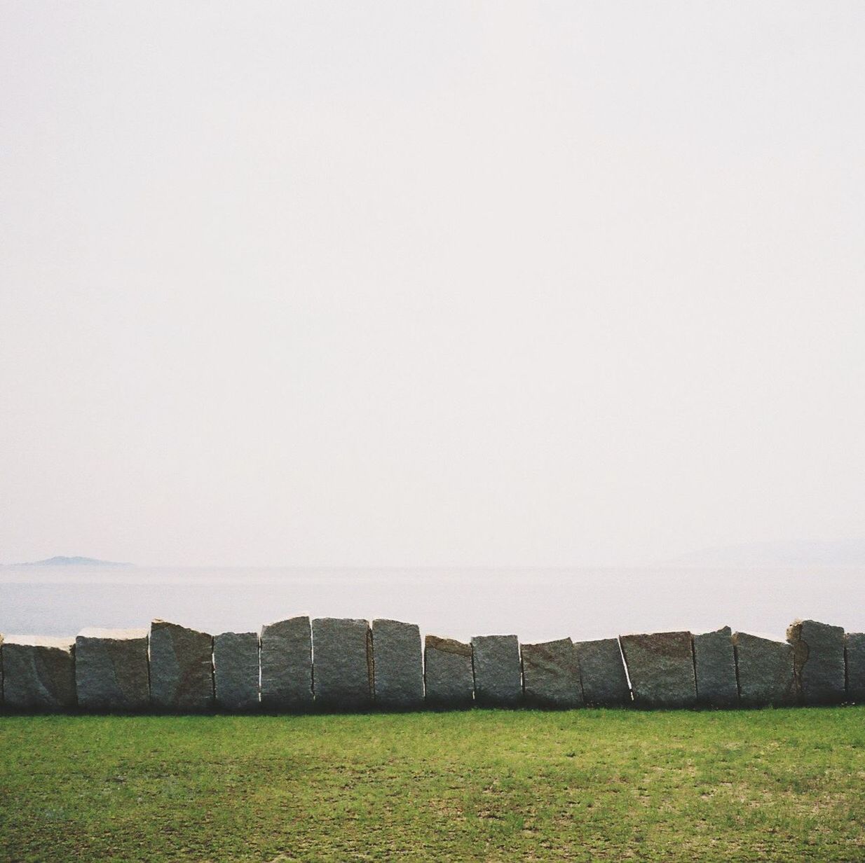 View of grassy field against clear sky