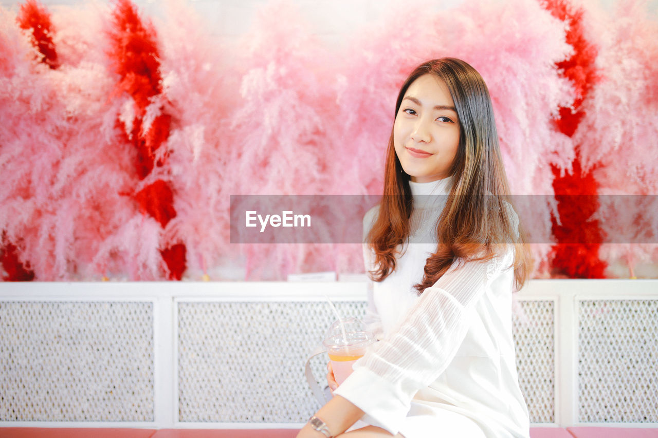 Woman sitting on bench by decorative wall